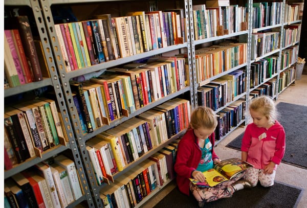 Two girls read in a second-hand bookshop